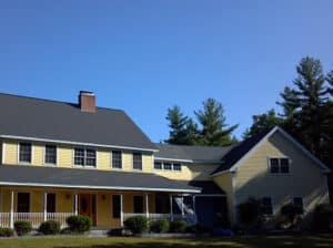 gray replacement roof on yellow house with white trim