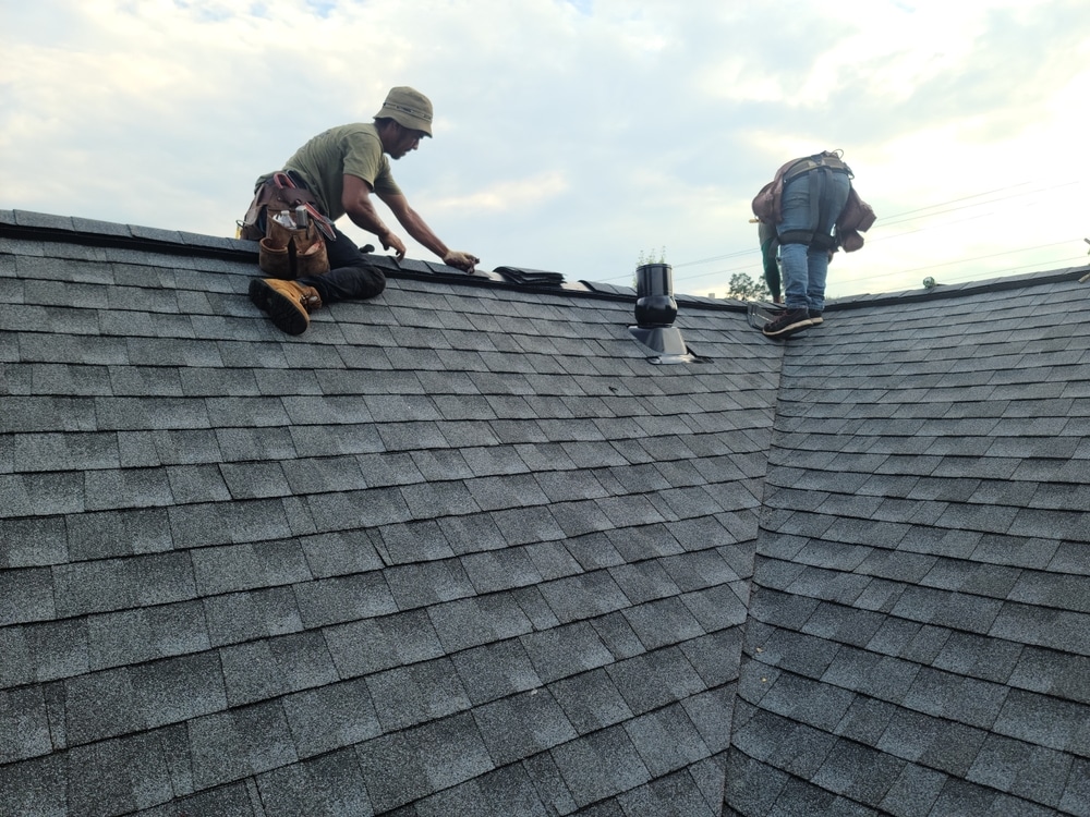 Roofer installing new shingles on the roof