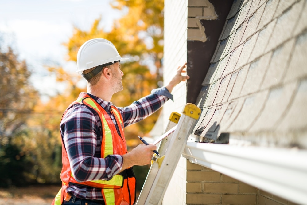 A professional roofing contractor inspecting a roof following wind damage