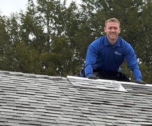 Adam Vaillancourt Roofing site manager smiling on a shingle roof during a repair